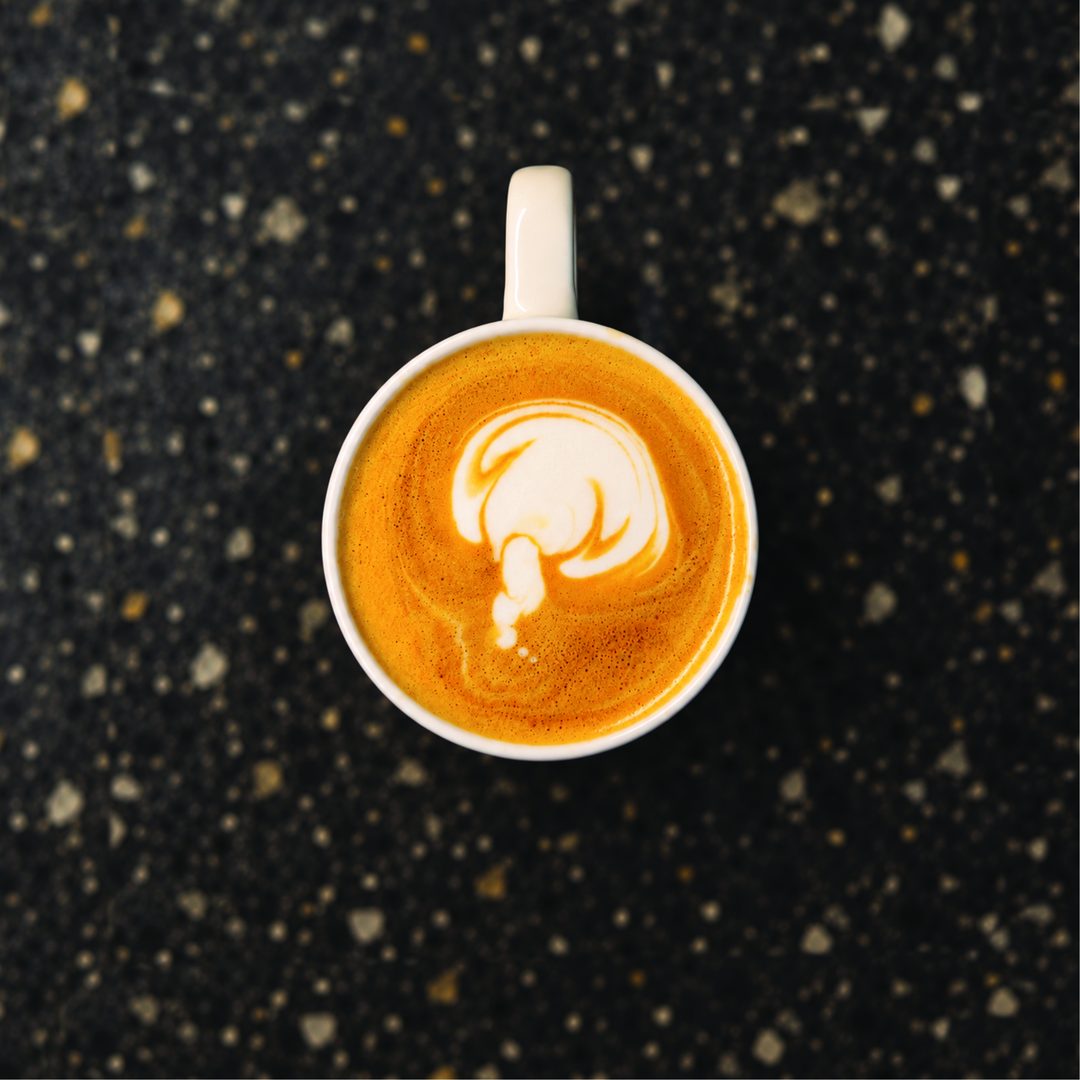 A coffee failing: a pale, lopsided blob of foam where a latte art shape should be