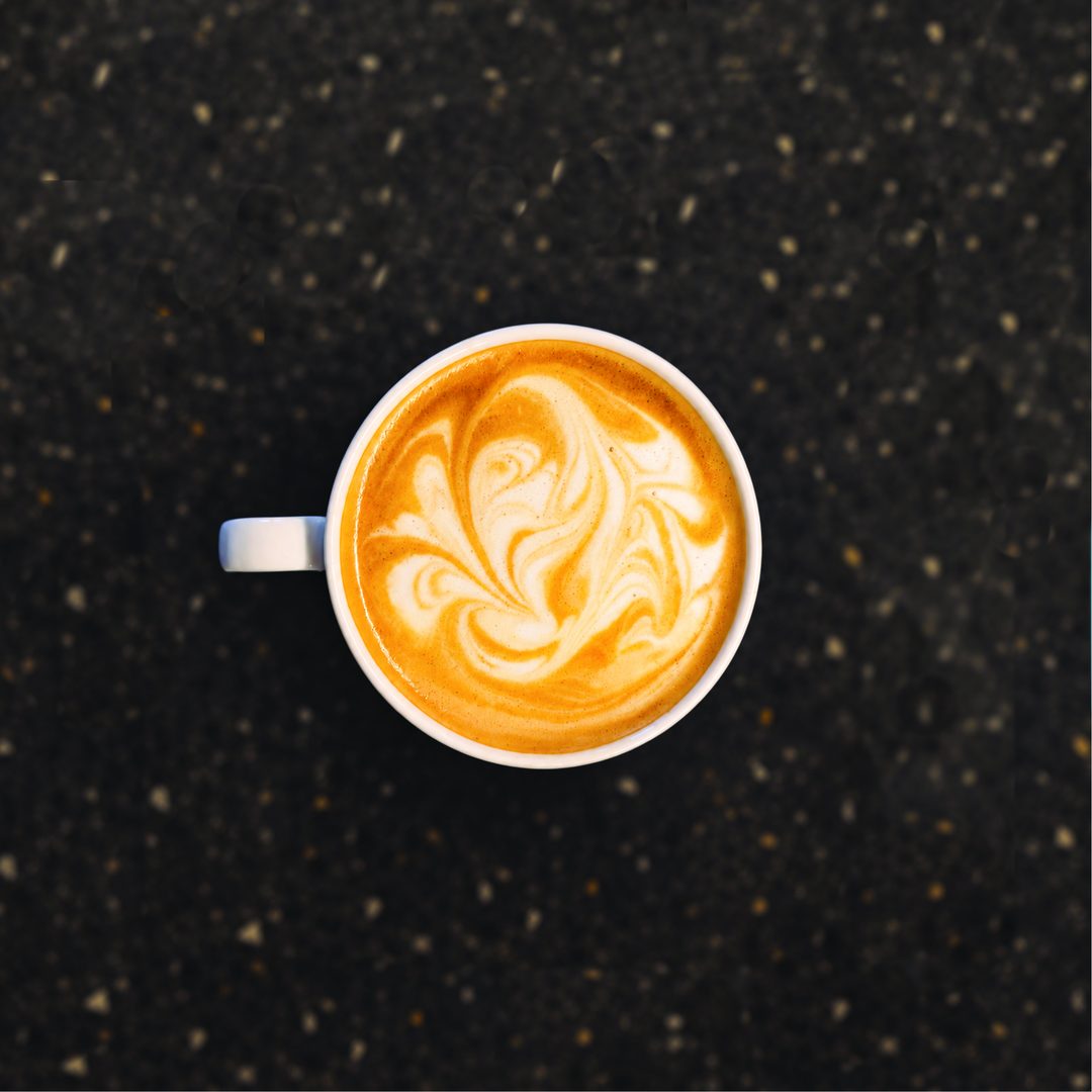 A coffee painting: the foam marbled into flowing swirls of cream and amber